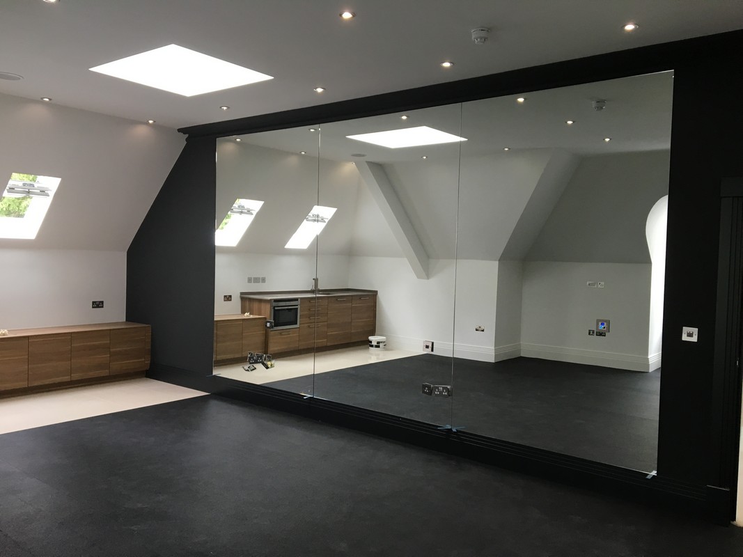 Frameless glass wall dividing loft conversion in Buckingham